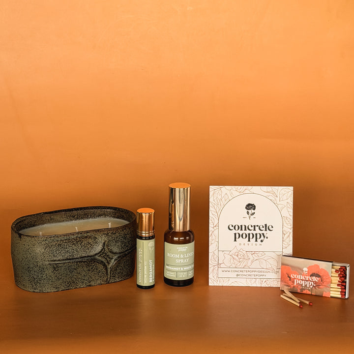 Premium eco-friendly gift set with rustic green ceramic oval candle, roll-on perfume oil and wildflower seeds